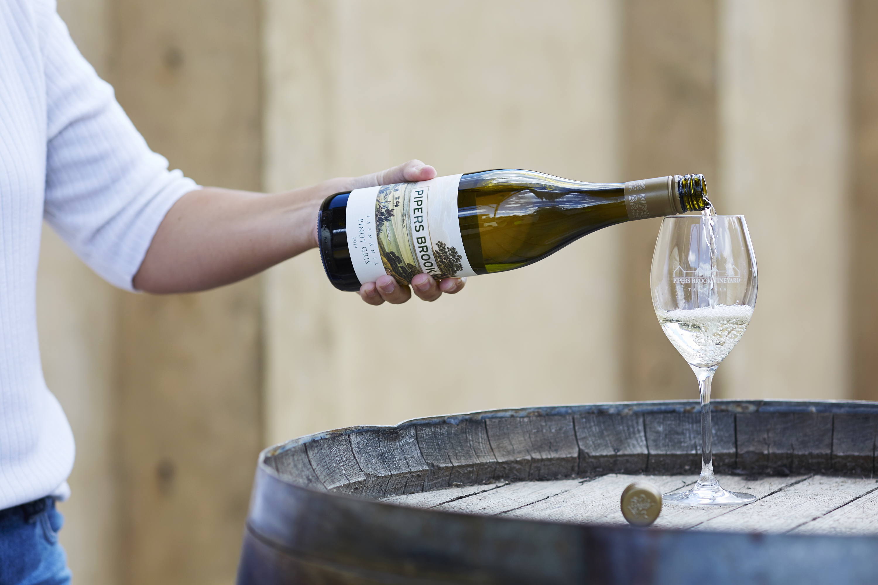 A man in white shirt pouring  Pipers Brook wines into a wineglass 